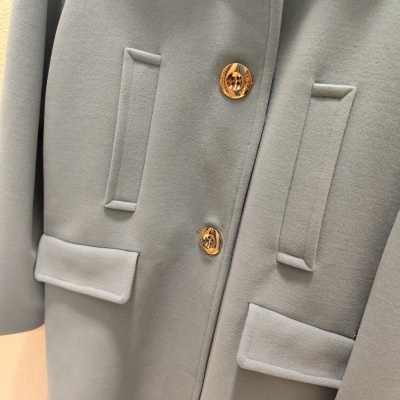 Casaco cinza claro com botões dourados e bolsos