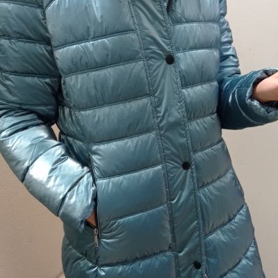 Casaco acolchoado azul brilhante com fecho e botões, usado por pessoa