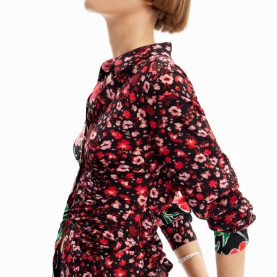 Blusa feminina floral branca, vermelha, rosa e verde com fundo preto.