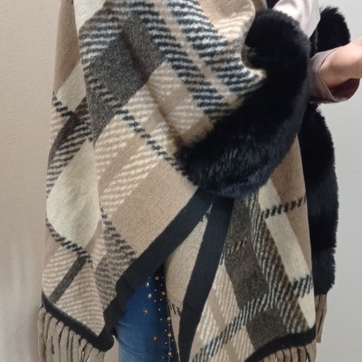 Poncho de xadrez bege, castanho e preto com pelúcia preta e franjas