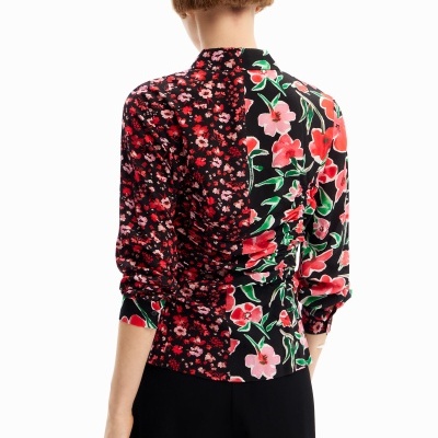 Blusa feminina com padrão floral dividido em duas partes sobre fundo branco.