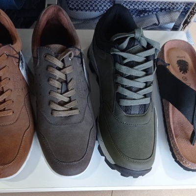 Quatro pares de calçado masculino e sandália mostrados lado a lado em cima de uma superfície clara