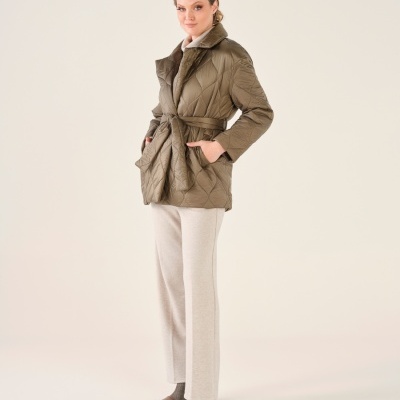 Mulher a usar casaco acolchoado verde-oliva com cinto e calças claras