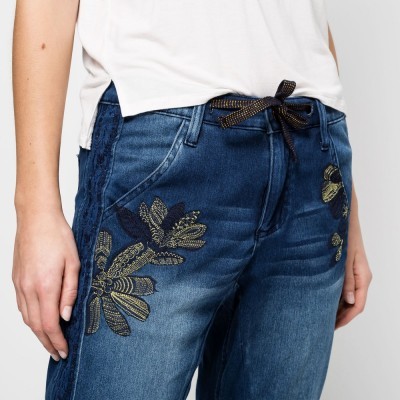 Calças de ganga azul com bordados florais em dourado e preto
