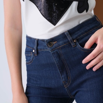 Calças de ganga azul escuro e t-shirt branca com apliques pretos e palavra BARROS