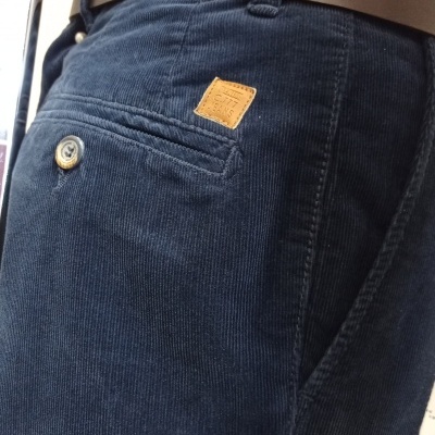 calças de veludo azul escuro com bolso traseiro e cinto castanho