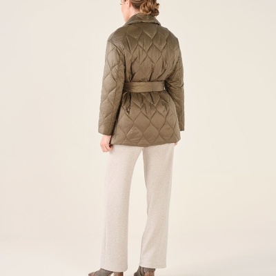 Casaco acolchoado verde com cinto usado por mulher vista de costas