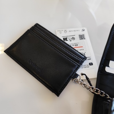 Carteira preta em pele com ranhuras para cartões e corrente metálica