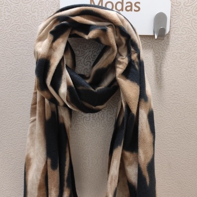 Lenço bege, castanho e preto pendurado em gancho branco com fundo de parede floral e texto Prince e Modas