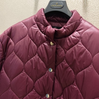 Casaco acolchoado vinho com botões dourados em cabide preto