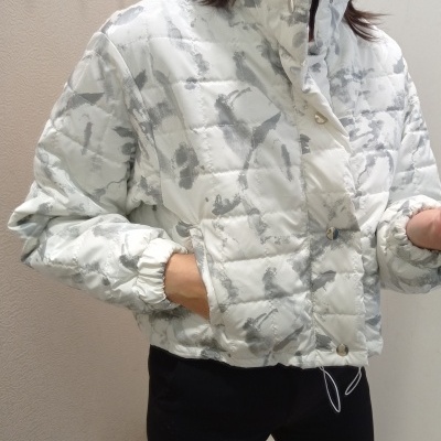 Casaco acolchoado branco com padrão cinza e botões prateados