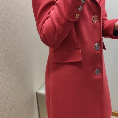 Casaco comprido vermelho com botões metálicos e bolsos