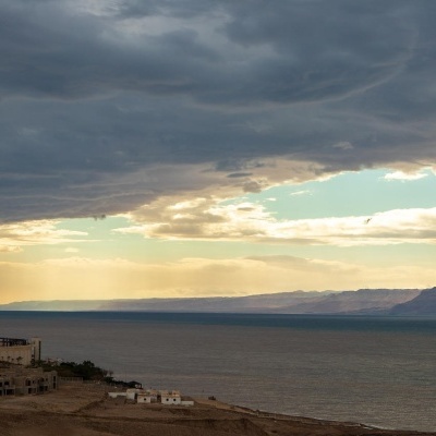 Vista do Mar Morto com céu nublado e edifícios à esquerda