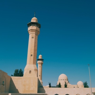 Mesquita de pedra bege com minaretes e cúpulas sob céu azul