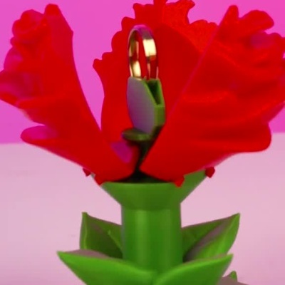 Flor vermelha artificial abrindo-se com um anel dourado escondido no centro