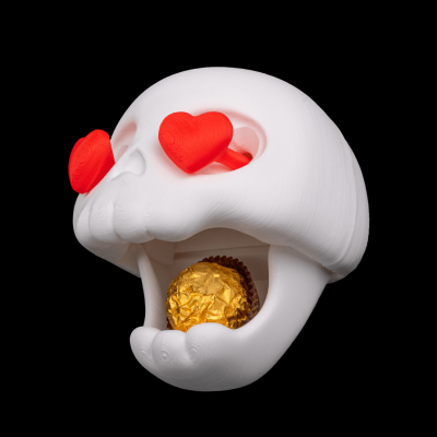 Caveira branca com olhos de coração vermelhos e bombom dourado na boca.