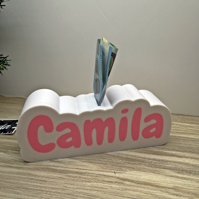 Pote de moeda branco em forma de nuvem com o nome Camila cor-de-rosa na frente