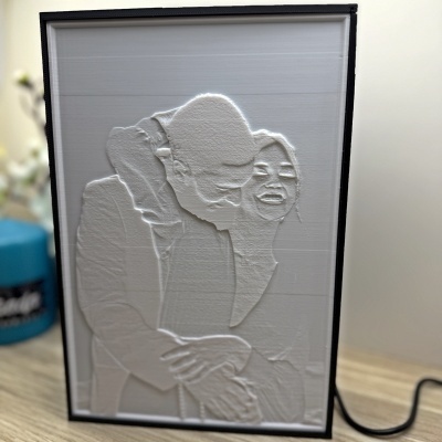 Relevo 3D branco de casal abraçado com moldura preta