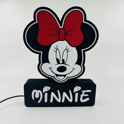 Objeto decorativo da Minnie com laço vermelho e base preta com texto MINNIE