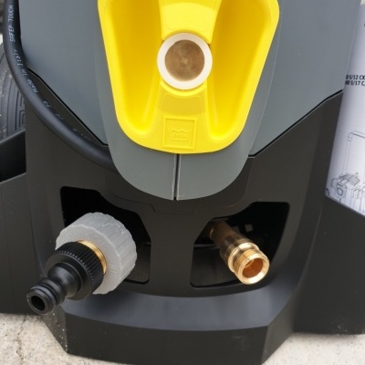 Máquina cinzenta com alça amarela, conectores metálicos e ligação de mangueira