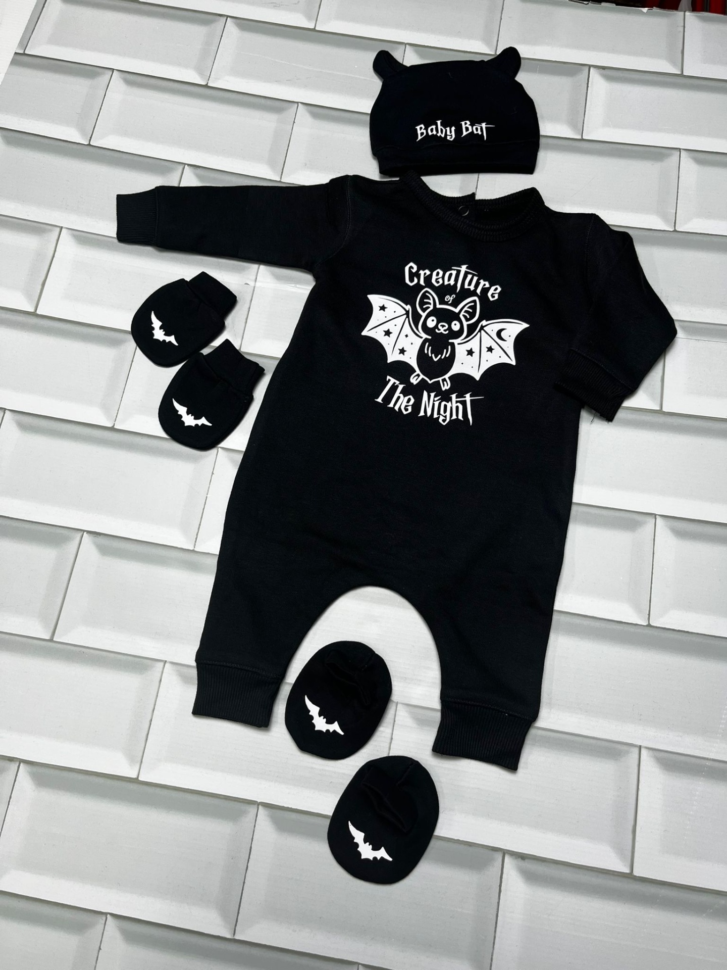 Conjunto de roupa de bebé preto com morcego e texto branco