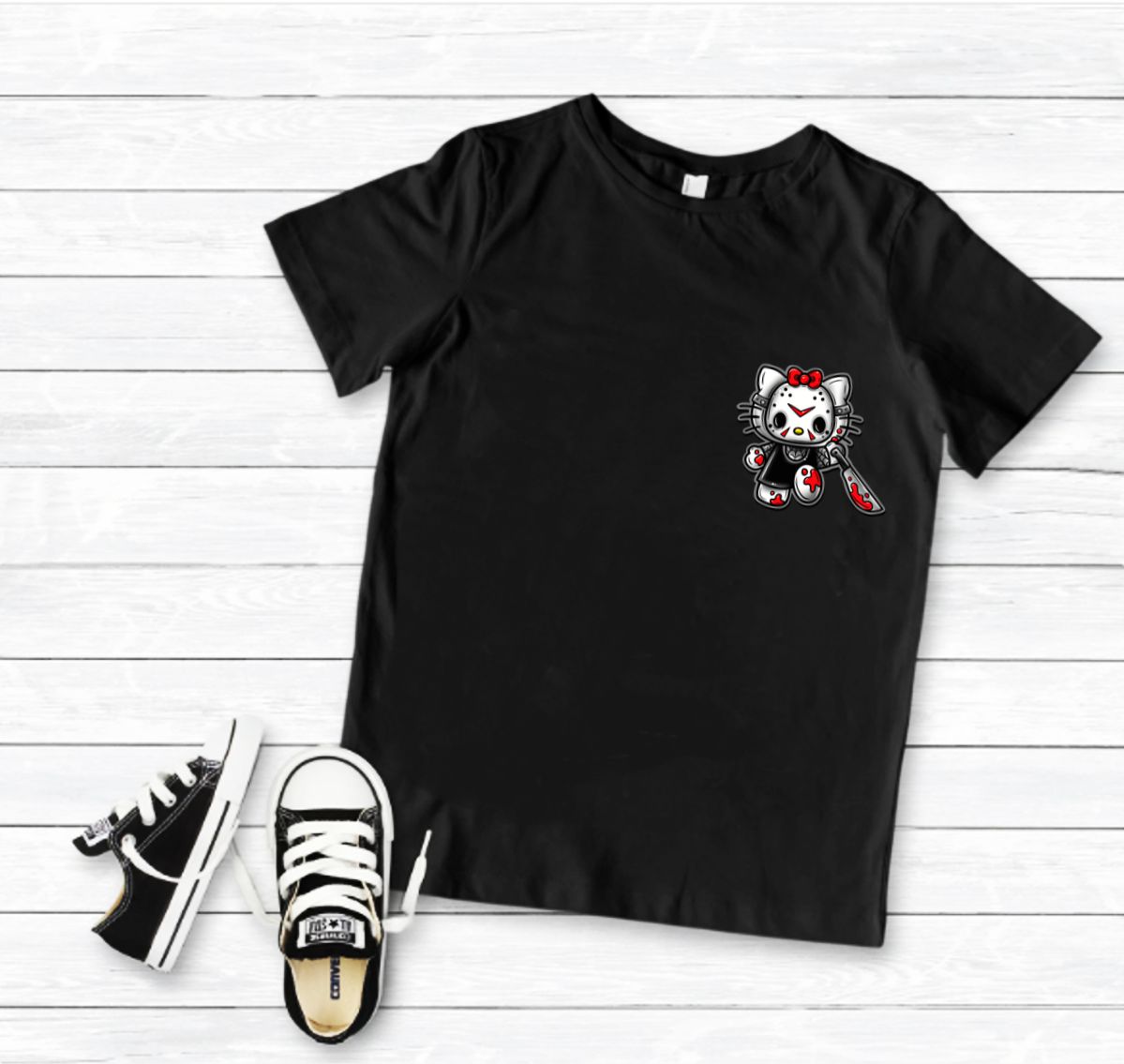 Camiseta preta com estampa de gato com laço vermelho ao peito e sapatilhas pretas e brancas ao lado