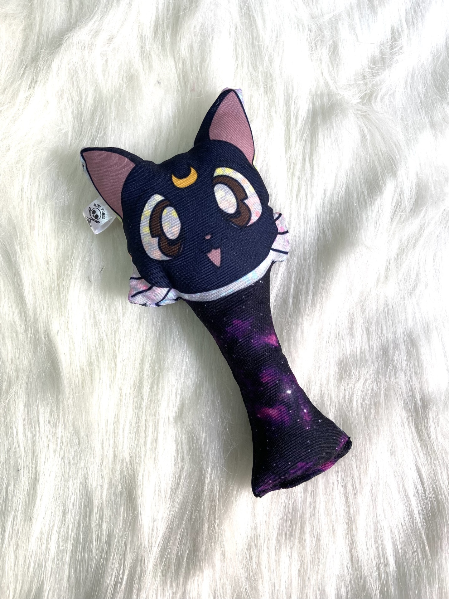 Brinquedo de pelúcia em forma de gato com padrão galáxia