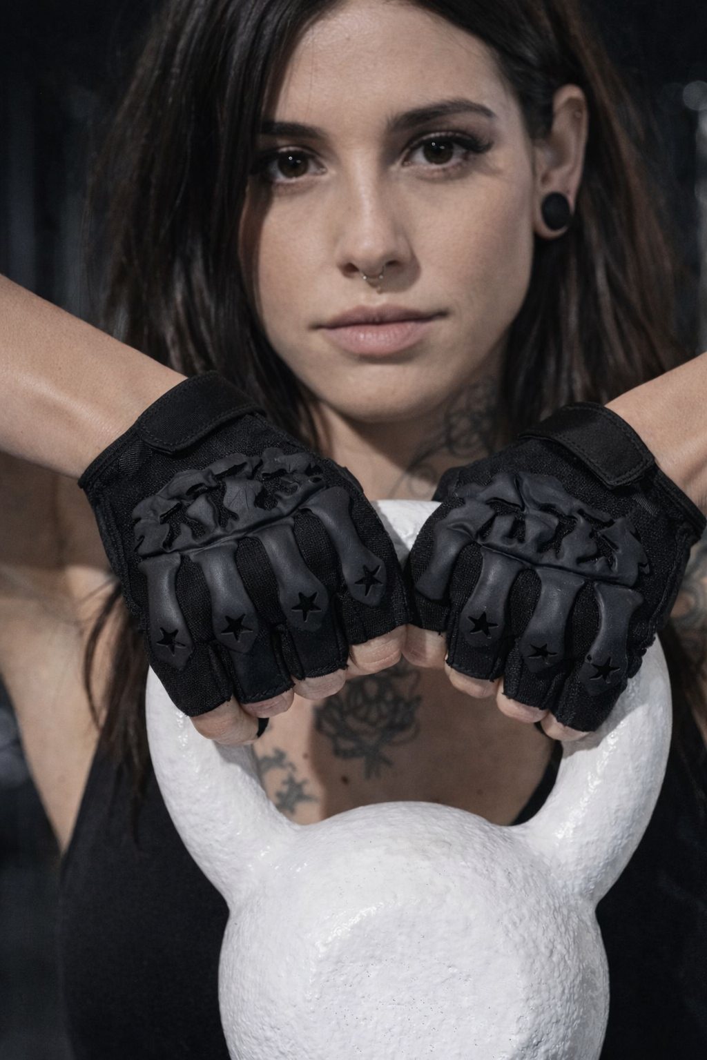 Mulher com luvas pretas de treino segurando kettlebell branco no ginásio