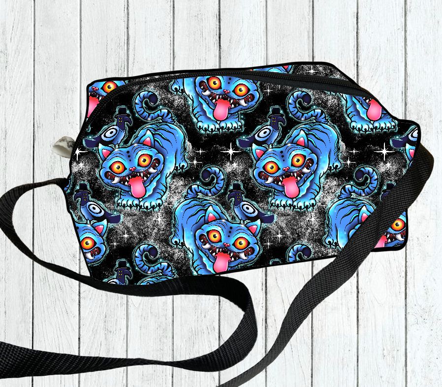 Saco mala com padrão de gatos azuis sobre fundo preto com brilhos