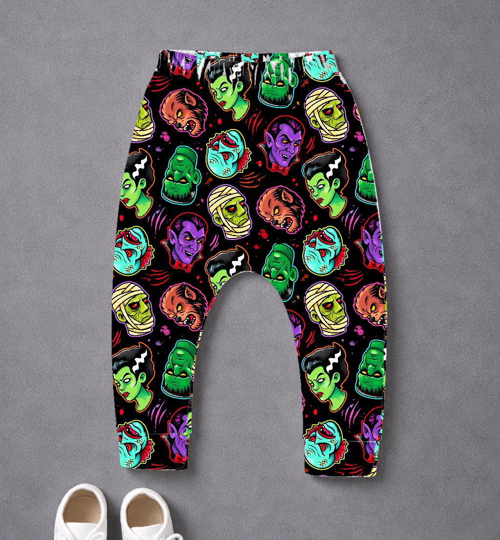 Calças infantis com padrão colorido de monstros clássicos em fundo preto