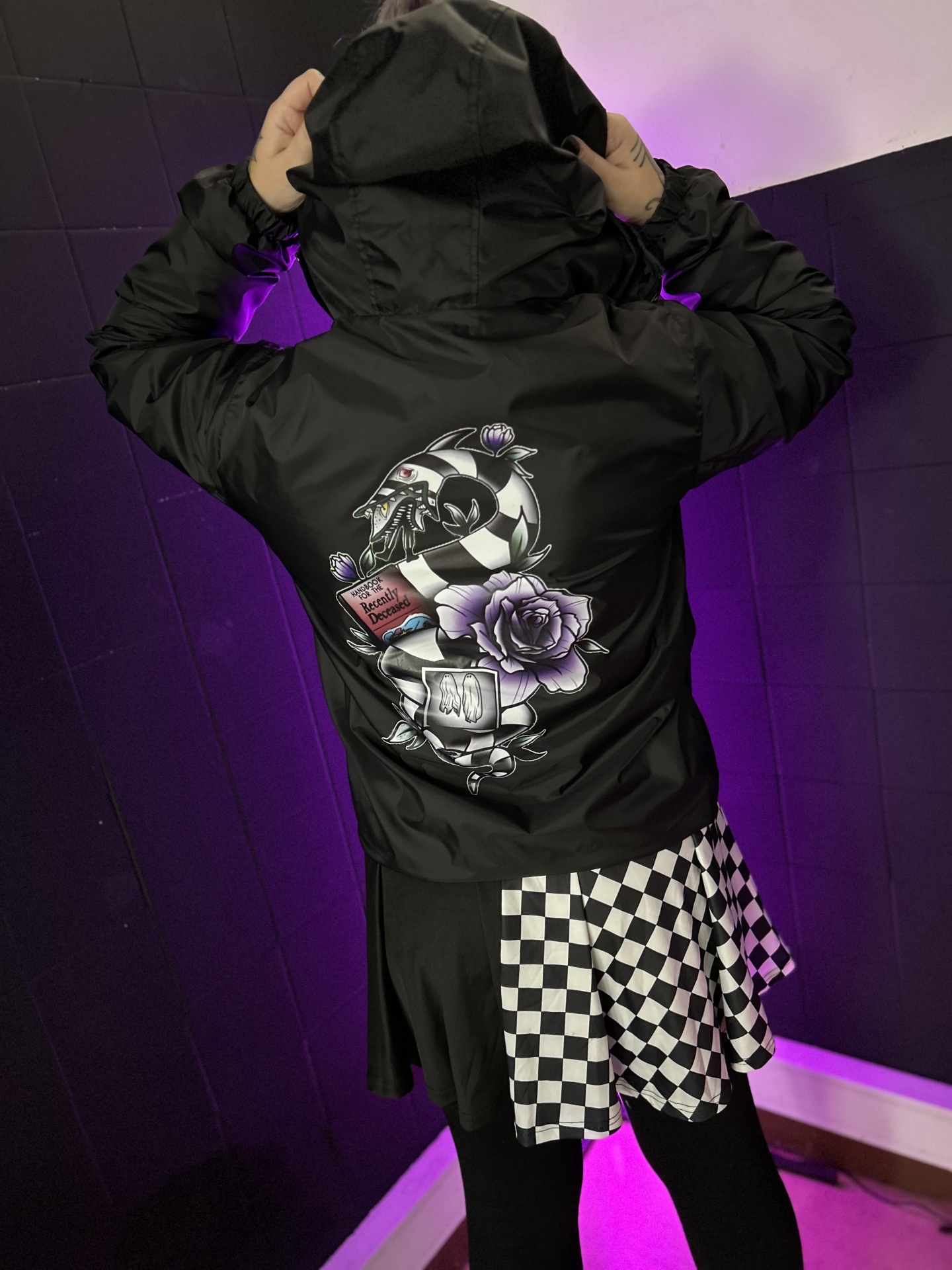 Casaco preto com estampa colorida e saia com padrão quadriculado