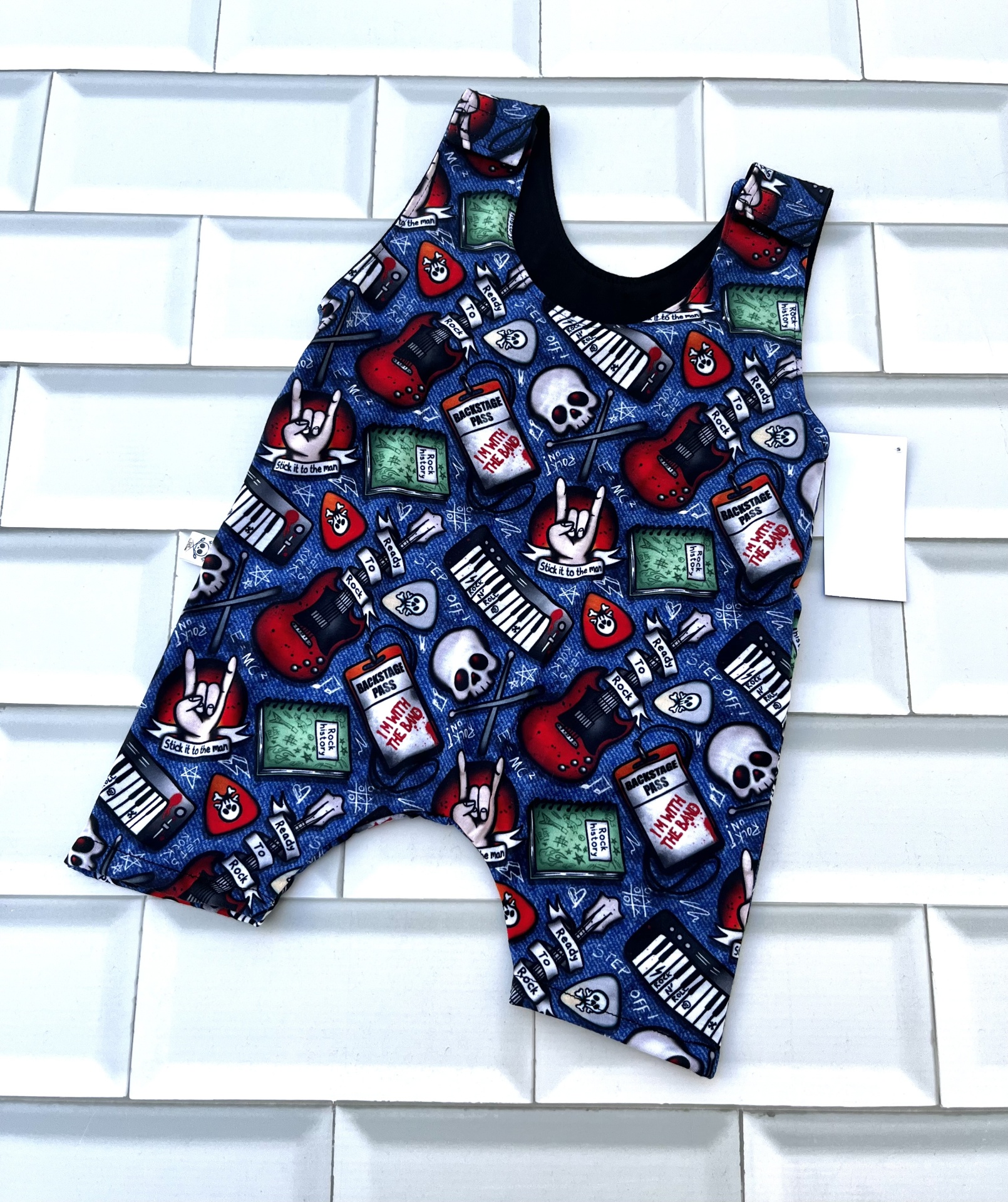 Macacão curto para bebé com padrão colorido de guitarras e caveiras