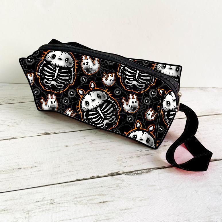 Necessaire preta com padrão de esqueletos e fantasmas brancos com detalhes laranja