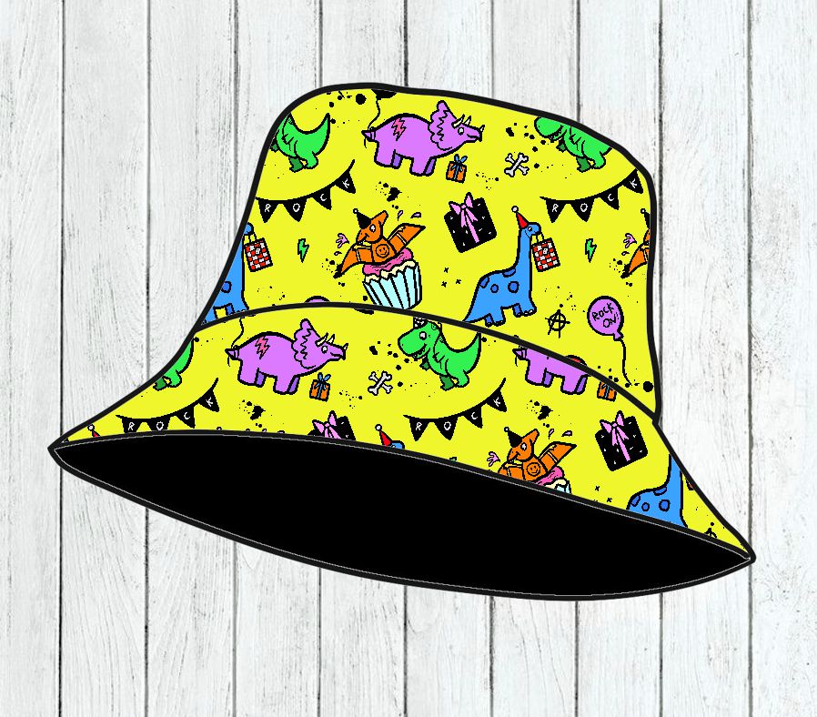 Chapéu de tecido amarelo com padrão de dinossauros coloridos e elementos festivos