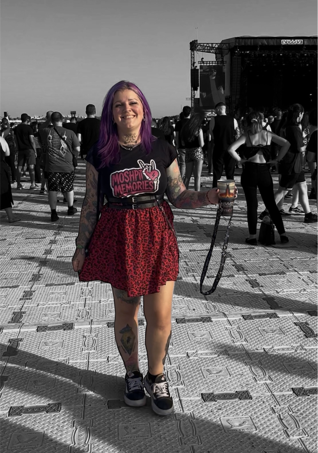 Mulher com t-shirt preta e saia vermelha num festival de música ao ar livre