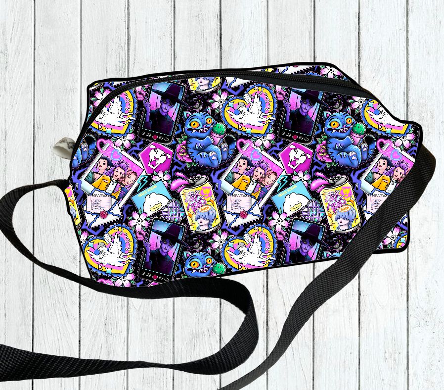 mala tiracolo com padrão colorido de corações e personagens