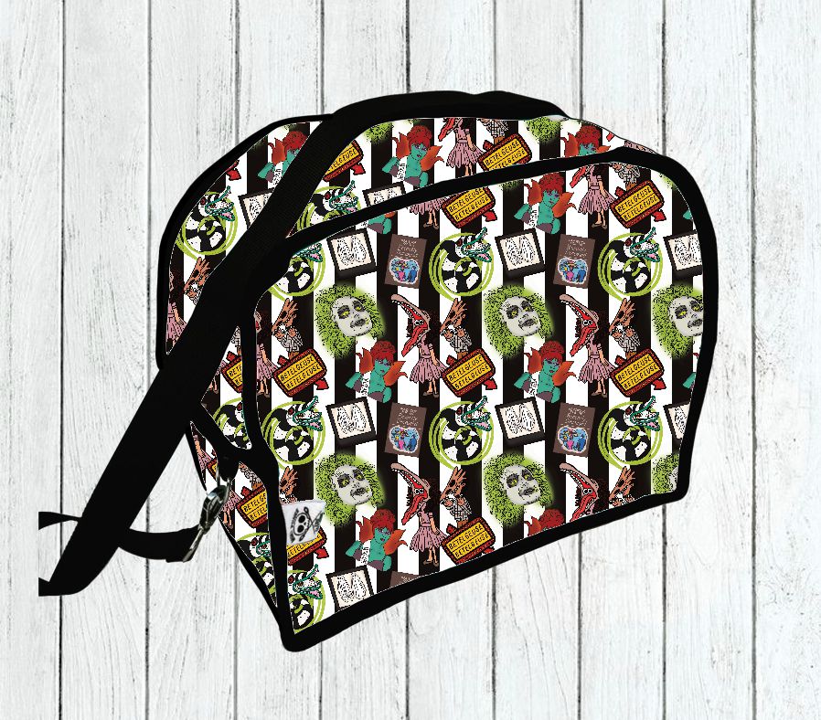 Bolsa colorida com padronagem e alça preta sobre fundo de madeira branca