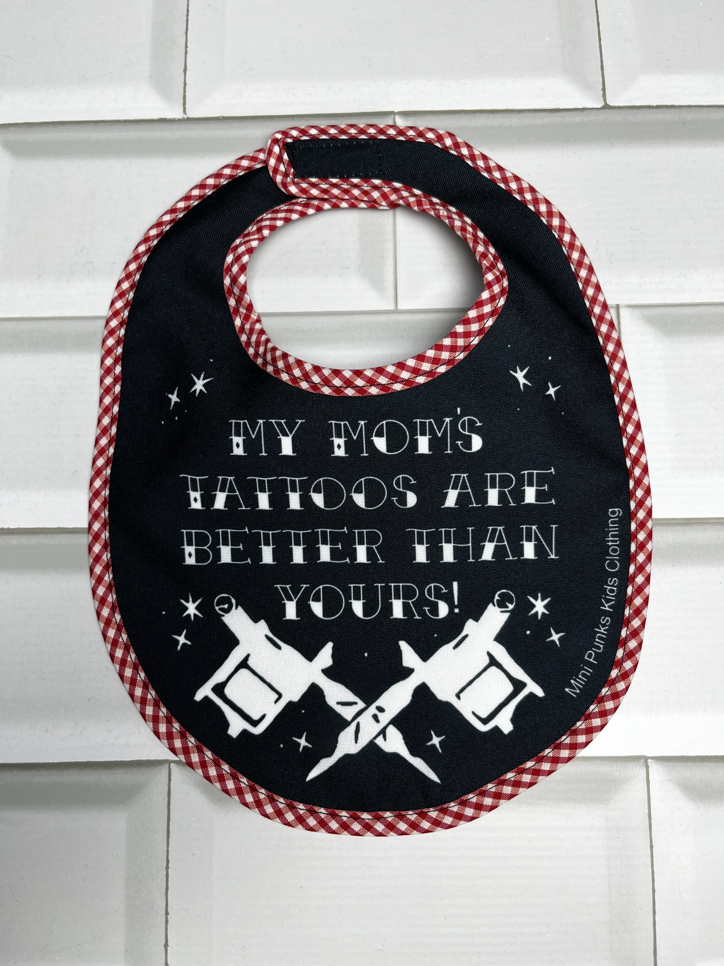 Babete para bebé preto com borda xadrez e texto divertido