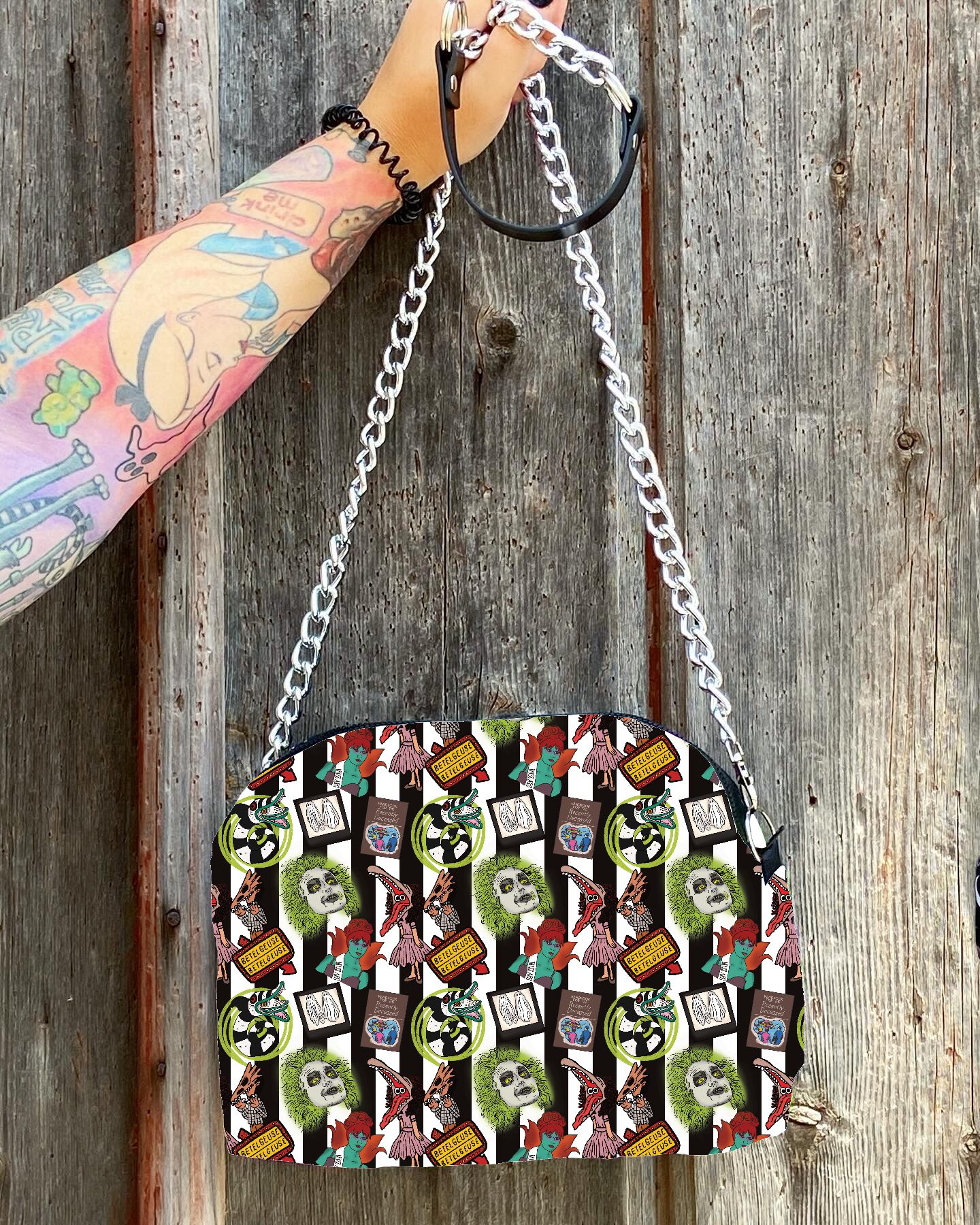 Bolsa colorida com padrão de caveiras, flores e envelopes com alça de corrente prateada