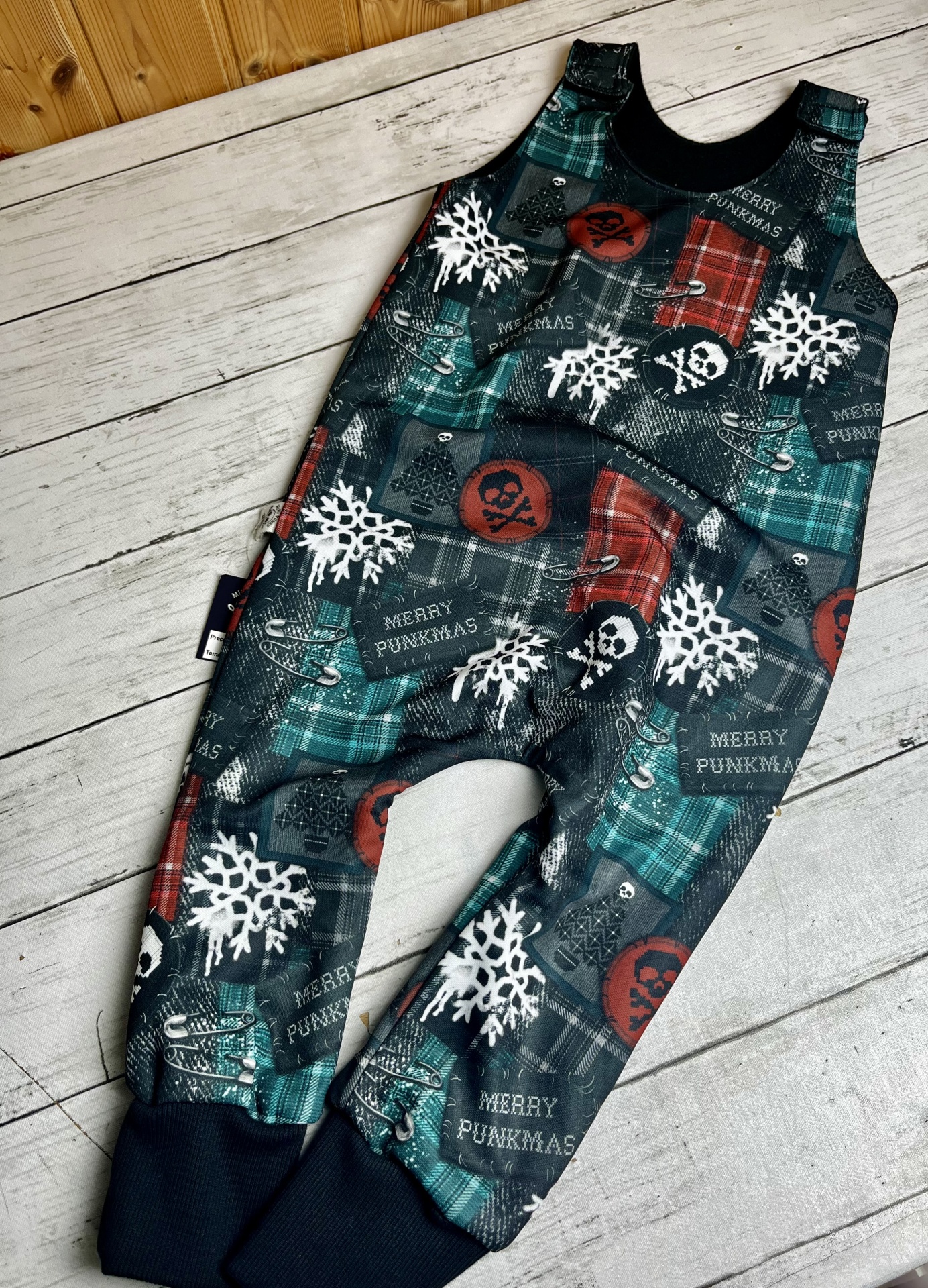 Macacão infantil xadrez com flocos de neve, caveiras, alfinetes e texto MERRY PUNKMAS