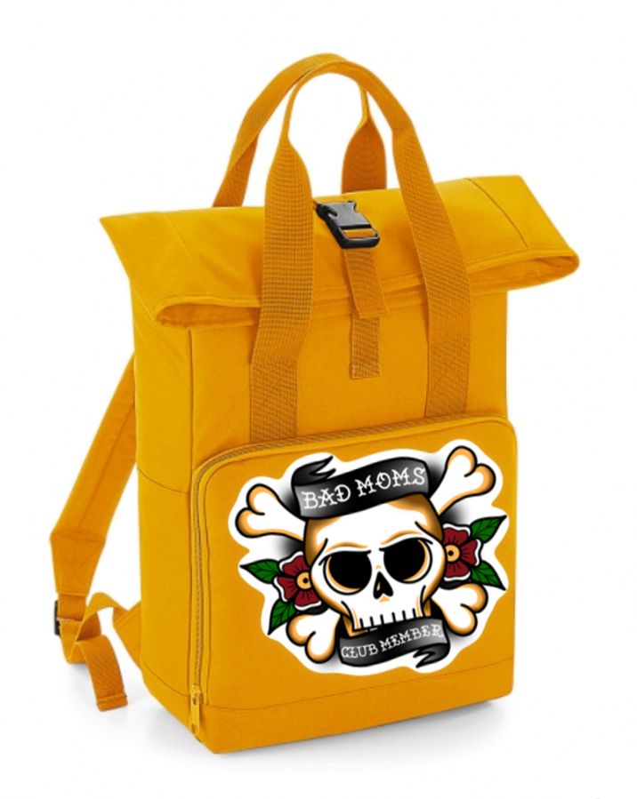 Mochila amarela com desenho de caveira e texto 'BAD MOMS CLUB MEMBER' no bolso frontal