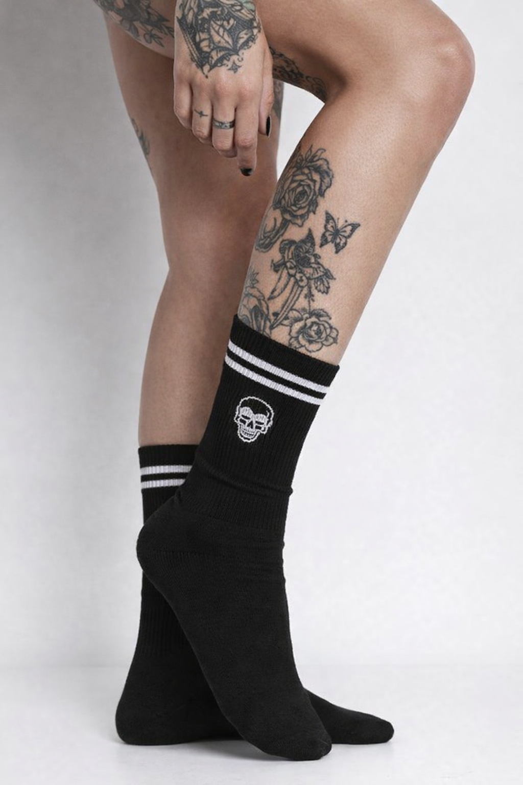 Meias negras com riscas brancas e caveira bordada