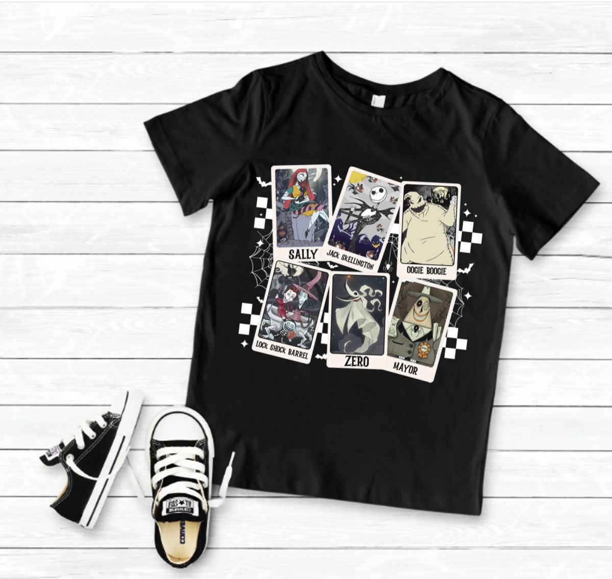 Camiseta preta com estampado frontal de personagens e ténis pretos com atacadores brancos.