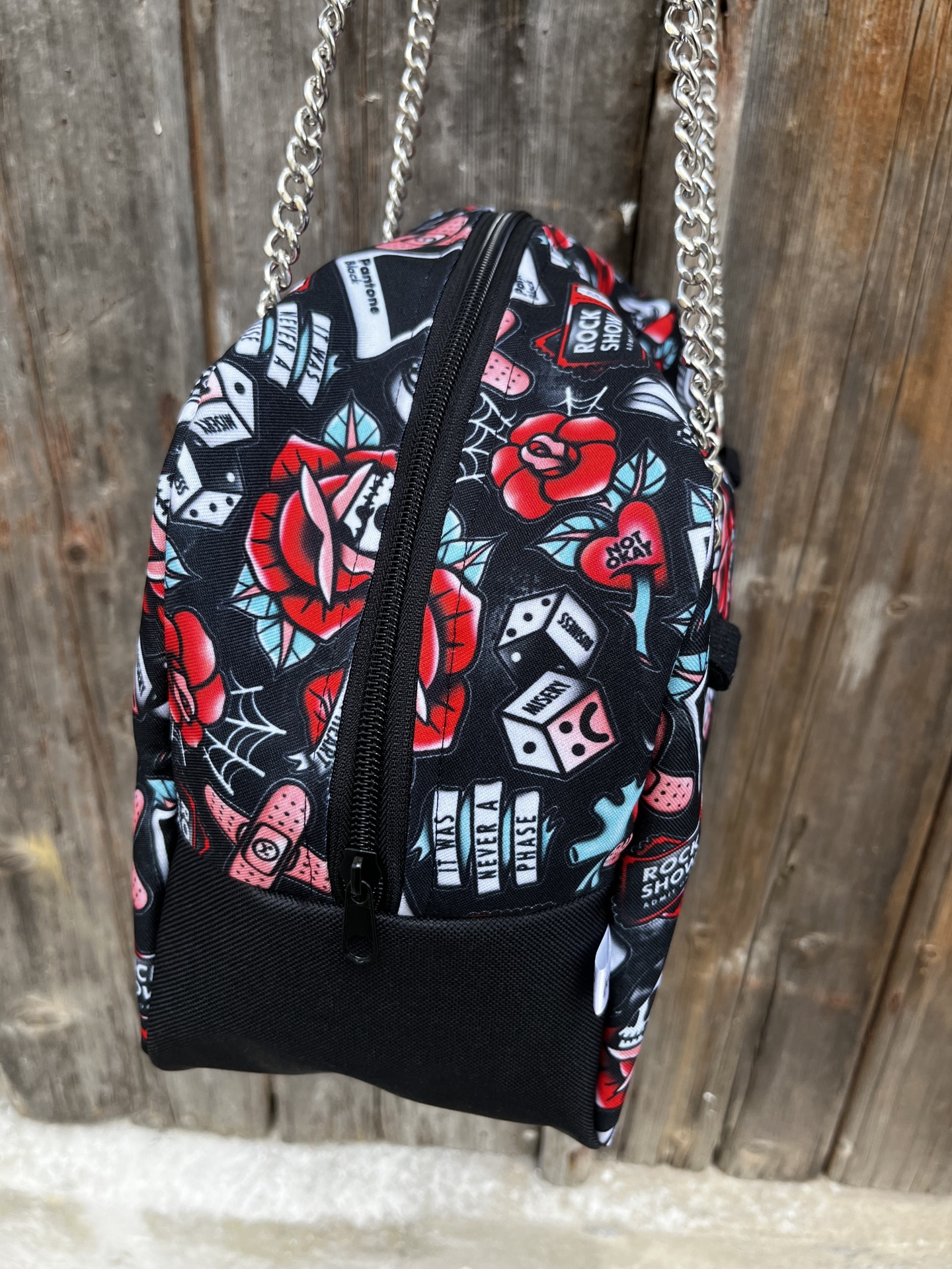 Mochila pequena colorida com padrão de rosas, dados e corações, correias de corrente metálica