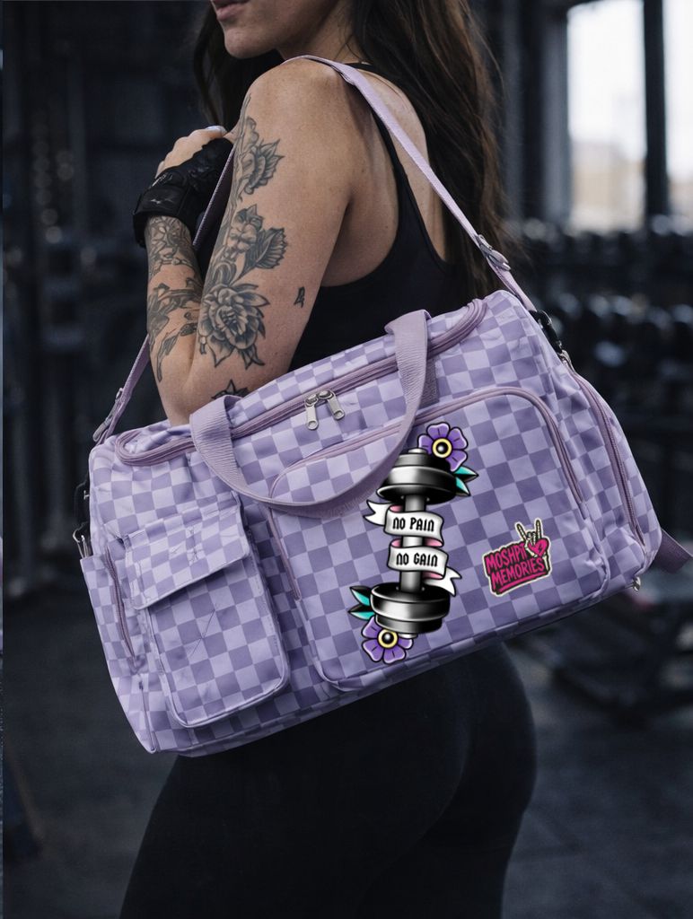 Mala desportiva lilás com padrão de quadrados e autocolantes, usada por mulher com tatuagens no ginásio