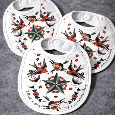 Três babetes brancos com design de tatuagem tradicional