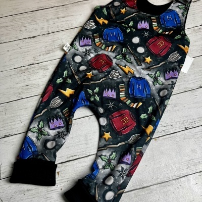 macacão infantil colorido com padrão de camisolas, varinhas, estrelas e óculos