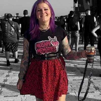 Pessoa com t-shirt preta e saia vermelha com padrão animal print num evento ao ar livre