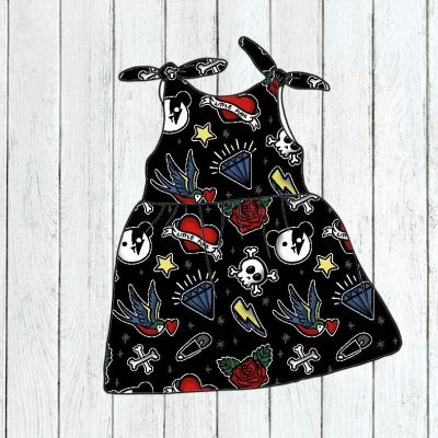 Vestido infantil preto com vários desenhos coloridos como caveiras, rosas, diamantes e corações.