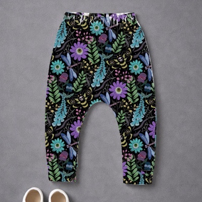 Calças de bebé com padrão colorido de flores e insetos sobre fundo preto